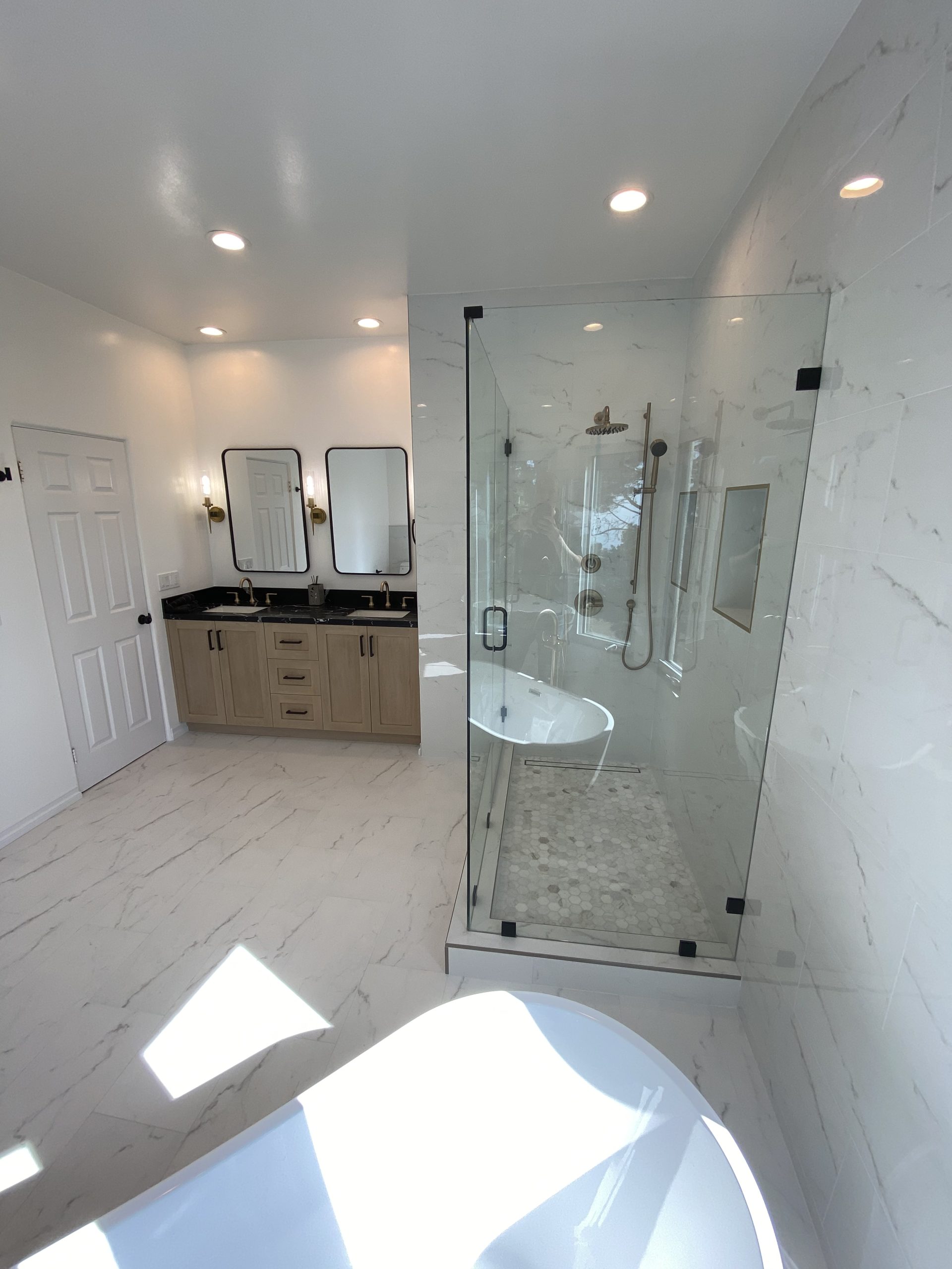 Luxury bathroom renovation with double vanity, custom cabinetry, and contemporary lighting design